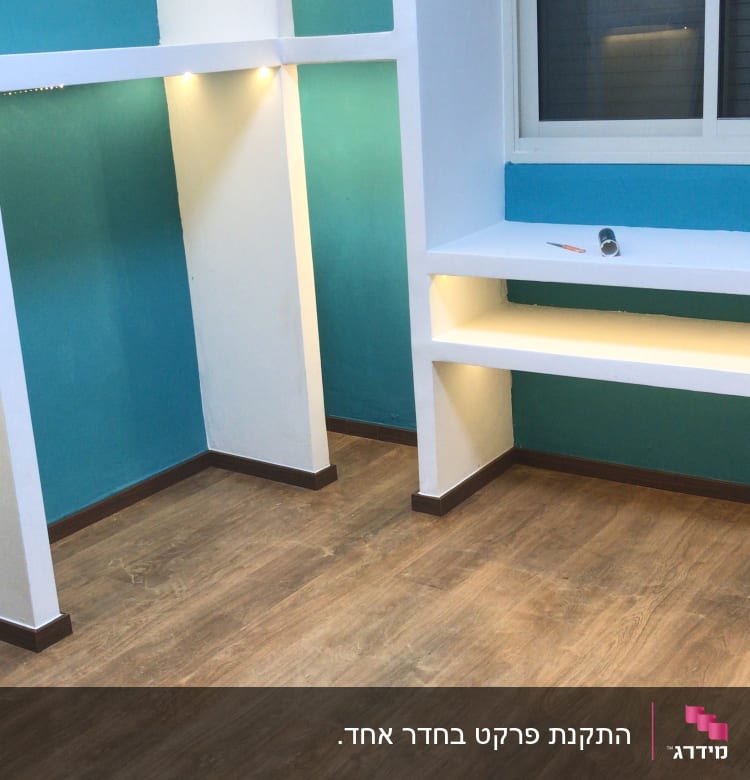 רצפת פרקט עץ בחדר עם קירות כחולים